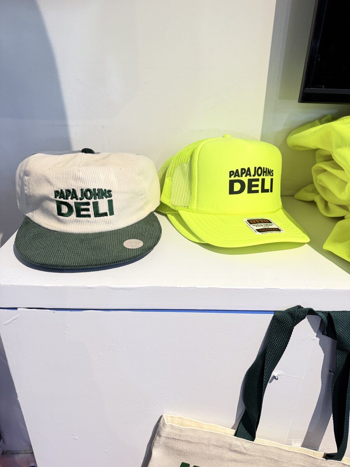 Branded merch display with folded shirts and signage inside a rented booth