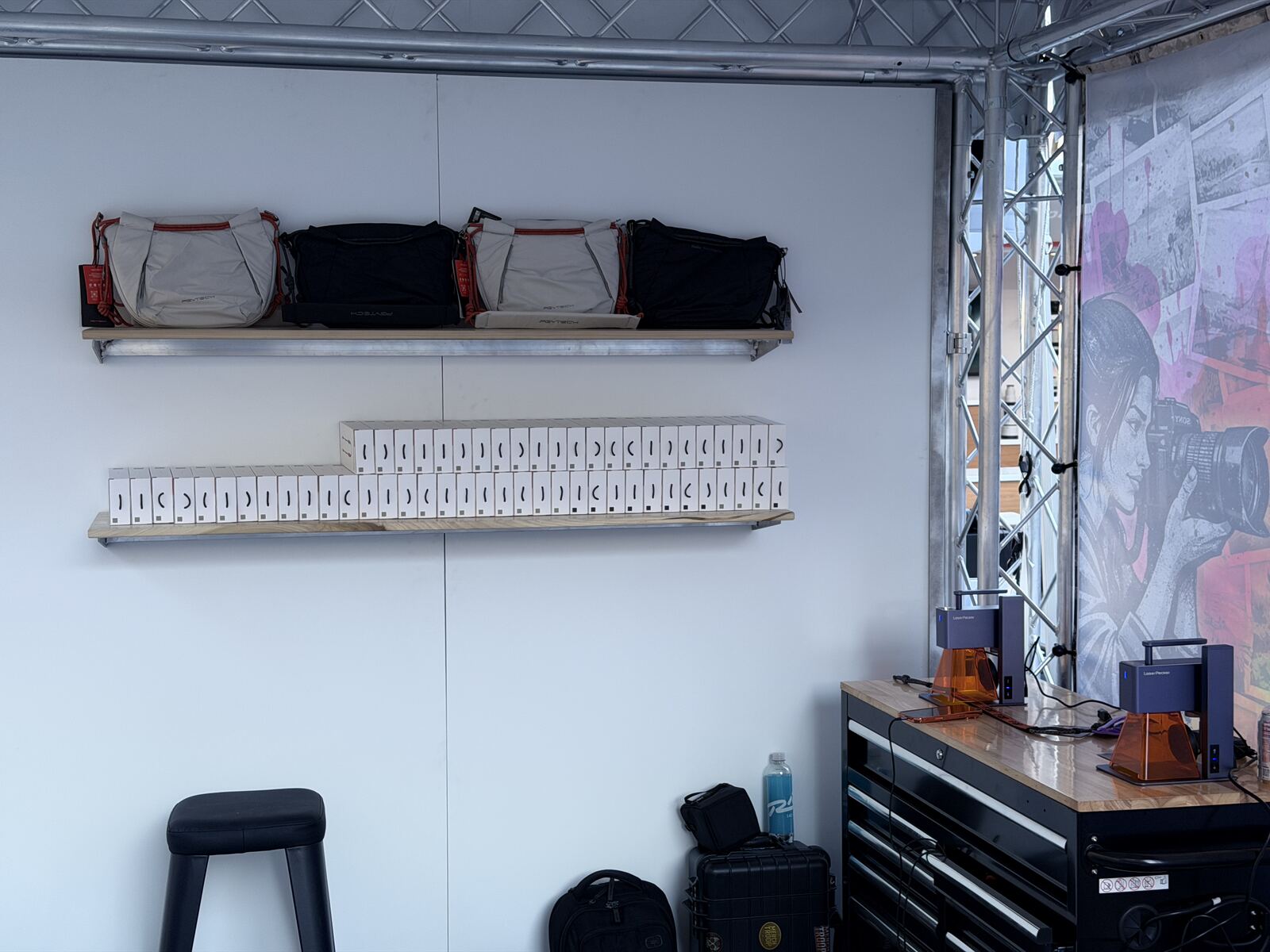 Organized booth setup with stored apparel bins and organized samples on display shelves